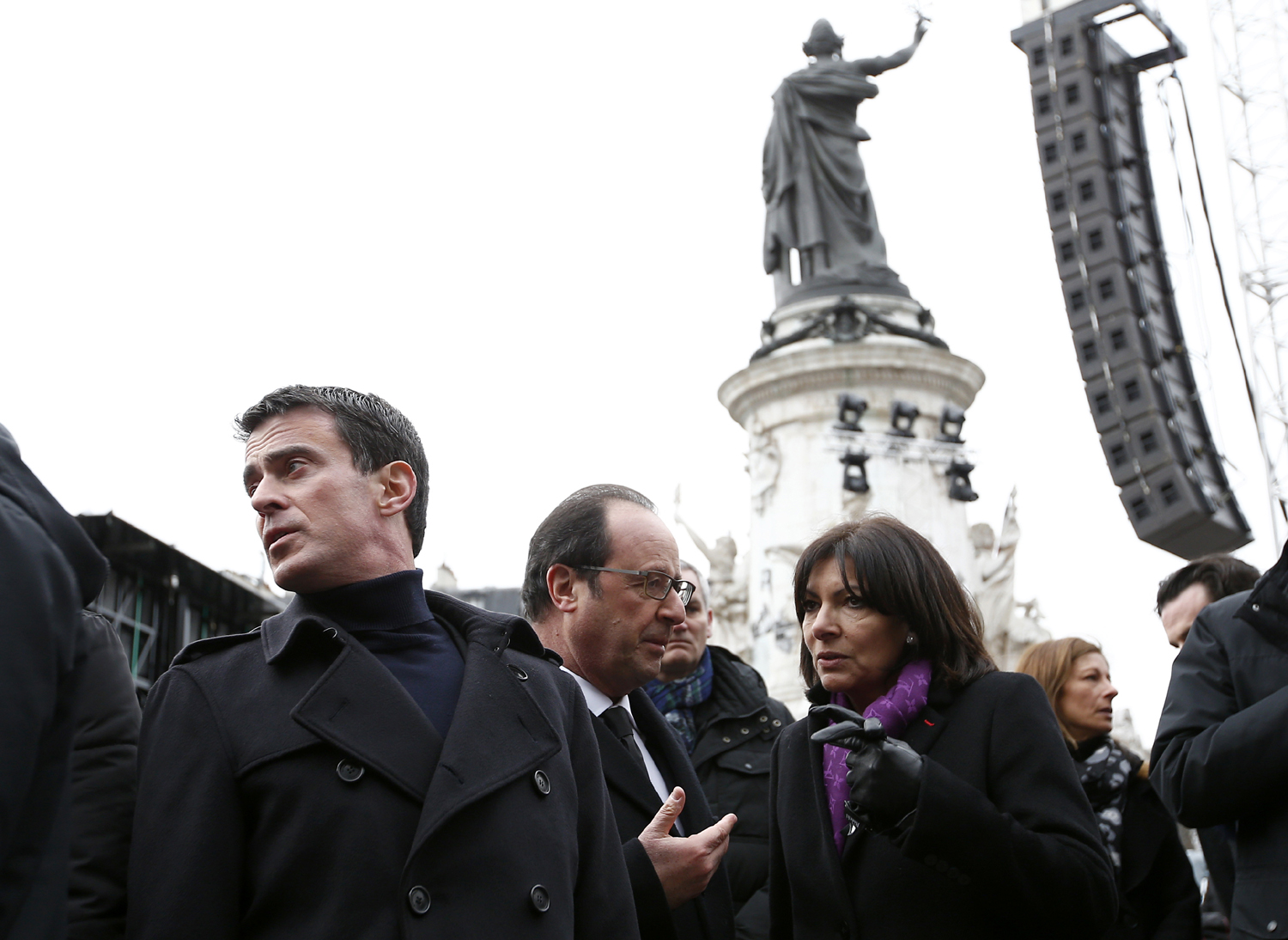 (From L) French Prime minister Manuel Valls, French President Francois Hollande and French Paris' mayor Anne Hidalgo attend a remembrance rally at Place de la Republique (Republic square) on January 10, 2016 to mark a year since 1.6 million people thronged the French capital in a show of unity after attacks on the Charlie Hebdo newspaper and a Jewish supermarket. Just as it was last year, the vast Place de la Republique will be the focus of the gathering as people reiterate their support for freedom of expression and remember the other victims of what would become a year of jihadist outrages in France, culminating in the November 13 coordinated shootings and suicide bombings that killed 130 people and were claimed by the Islamic State (IS) group. / AFP / YOAN VALAT
