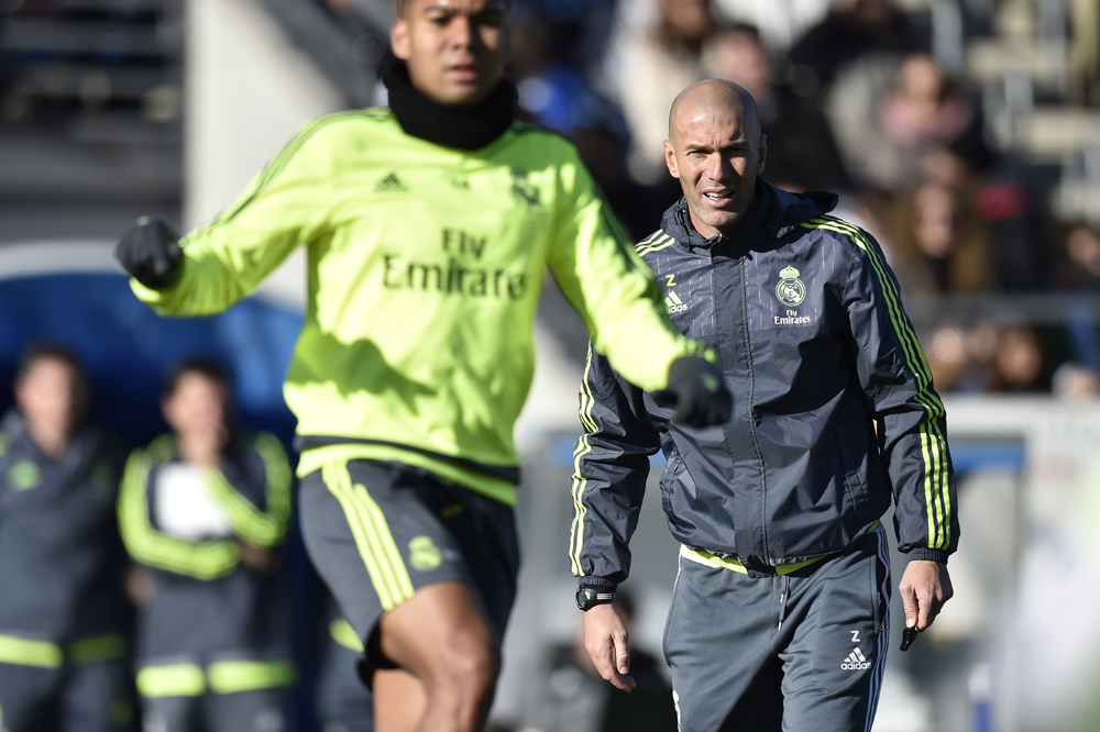 Real Madrid's new French coach Zinedine Zidane (R) looks at his players during his first training session as coach of Real Madrid at the Alfredo di Stefano stadium in Valdebebas, on the outskirts of Madrid, on January 5, 2016. Real Madrid legend Zinedine Zidane promised to put his "heart and soul" into managing the Spanish giants after he was sensationally named as coach following Rafael Benitez's unceremonious sacking. AFP PHOTO/ GERARD JULIEN / AFP / GERARD JULIEN