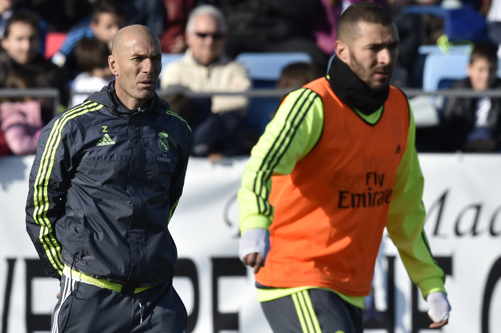 Real Madrid's new French coach Zinedine Zidane (L) looks at his players during his first training session as coach of Real Madrid at the Alfredo di Stefano stadium in Valdebebas, on the outskirts of Madrid, on January 5, 2016. Real Madrid legend Zinedine Zidane promised to put his "heart and soul" into managing the Spanish giants after he was sensationally named as coach following Rafael Benitez's unceremonious sacking. AFP PHOTO/ GERARD JULIEN / AFP / GERARD JULIEN