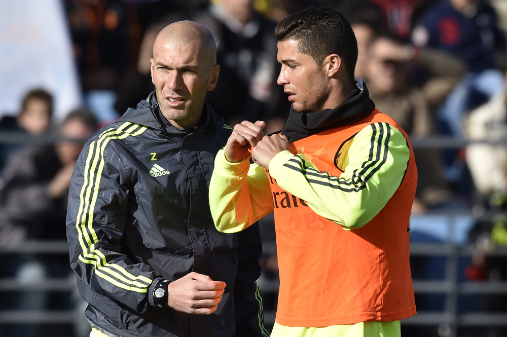 Real Madrid's new French coach Zinedine Zidane (L) and Real Madrid's Portuguese forward Cristiano Ronaldo gesture during his first training session as coach of Real Madrid at the Alfredo di Stefano stadium in Valdebebas, on the outskirts of Madrid, on January 5, 2016. Real Madrid legend Zinedine Zidane promised to put his "heart and soul" into managing the Spanish giants after he was sensationally named as coach following Rafael Benitez's unceremonious sacking. AFP PHOTO/ GERARD JULIEN / AFP / GERARD JULIEN