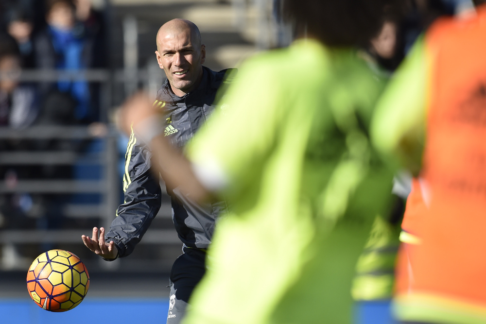 Real Madrid's new French coach Zinedine Zidane throws a ball during his first training session as coach of Real Madrid at the Alfredo di Stefano stadium in Valdebebas, on the outskirts of Madrid, on January 5, 2016. Real Madrid legend Zinedine Zidane promised to put his "heart and soul" into managing the Spanish giants after he was sensationally named as coach following Rafael Benitez's unceremonious sacking. AFP PHOTO/ GERARD JULIEN / AFP / GERARD JULIEN