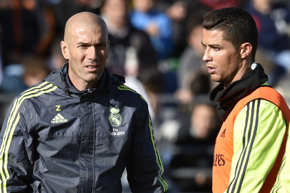 Real Madrid's new French coach Zinedine Zidane (L) walks past Real Madrid's Portuguese forward Cristiano Ronaldo during his first training session as coach of Real Madrid at the Alfredo di Stefano stadium in Valdebebas, on the outskirts of Madrid, on January 5, 2016. Real Madrid legend Zinedine Zidane promised to put his "heart and soul" into managing the Spanish giants after he was sensationally named as coach following Rafael Benitez's unceremonious sacking. AFP PHOTO/ GERARD JULIEN / AFP / GERARD JULIEN