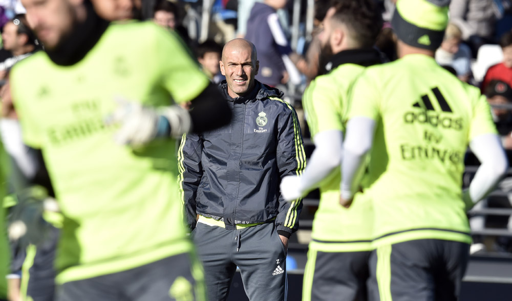 Real Madrid's new French coach Zinedine Zidane (C) looks at his players during his first training session as coach of Real Madrid at the Alfredo di Stefano stadium in Valdebebas, on the outskirts of Madrid, on January 5, 2016. Real Madrid legend Zinedine Zidane promised to put his "heart and soul" into managing the Spanish giants after he was sensationally named as coach following Rafael Benitez's unceremonious sacking. AFP PHOTO/ GERARD JULIEN / AFP / GERARD JULIEN