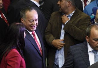 Diosdado Cabello (C), outgoing president of the National Assembly, accompanied by Venezuela's first lady, Cilia Flores (L), arrives at the parliament in Caracas, on January 5, 2016. Venezuela's President Nicolas Maduro ordered the security forces to ensure the swearing-in of a new opposition-dominated legislature passes off peacefully Tuesday, after calls for rallies raised fears of unrest. AFP PHOTO/JUAN BARRETO / AFP / JUAN BARRETO
