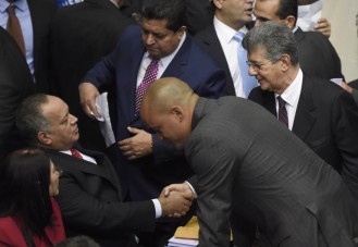 Diosdado Cabello (L), outgoing president of the National Assembly, shakes hands with the new parliament president Henry Ramos Allup (R) at the parliament in Caracas, on January 5, 2016. Venezuela's President Nicolas Maduro ordered the security forces to ensure the swearing-in of a new opposition-dominated legislature passes off peacefully Tuesday, after calls for rallies raised fears of unrest. AFP PHOTO/JUAN BARRETO / AFP / JUAN BARRETO