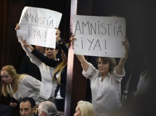 Opposition supporters show placards that read "Amnesty Now!" during the installation of the new parliament in Caracas, on January 5, 2016. Venezuela's President Nicolas Maduro ordered the security forces to ensure the swearing-in of a new opposition-dominated legislature passes off peacefully Tuesday, after calls for rallies raised fears of unrest. AFP PHOTO/JUAN BARRETO / AFP / JUAN BARRETO
