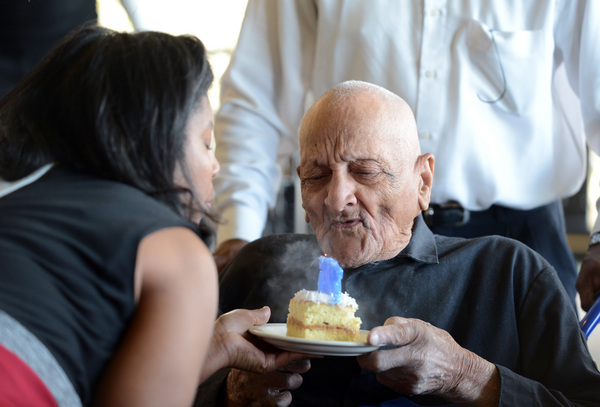 With a little help from daughter Delane Sims, Andrew Hatch blows out candles on his cake as he celebrates his 115th birthday in Oakland, Calif., on Monday, Oct. 7, 2013. (Kristopher Skinner/Bay Area News Group)