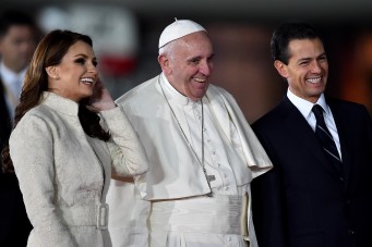Pope Francis (C), Mexican President Enrique Pena Nieto (R) and First Lady Angelica Rivera (L) smile upon the Pope's arrival at Benito Juarez international airport in Mexico City on February 12, 2016. Catholic faithful flocked to the streets of Mexico City to greet Pope Francis on Friday after the pontiff held a historic meeting with the head of the Russian Orthodox Church in Cuba. AFP PHOTO/ GABRIEL BOUYS / AFP / GABRIEL BOUYS