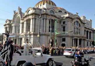 Pope Francis waves from the popemobile on his way to the Guadalupe Basilica in Mexico City on February 13, 2016. Francis will be the first pope to enter Mexico's National Palace to meet President Enrique Pena Nieto, as he starts a cross-country tour that will highlight the country's violence and migration troubles. AFP PHOTO/MARIO VAZQUEZ / AFP / MARIO VAZQUEZ