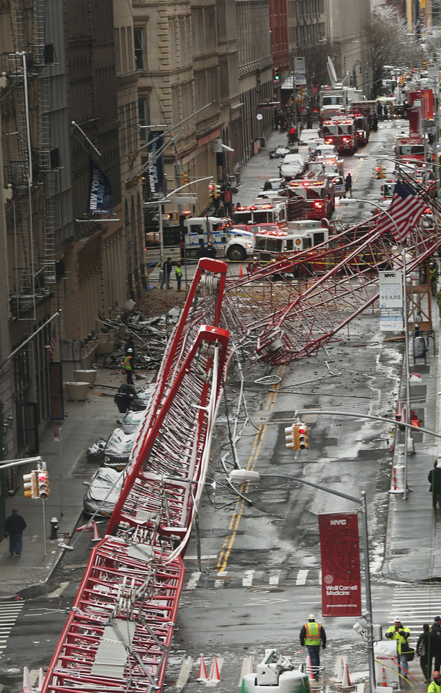 NEW YORK, NY - FEBRUARY 05: Emergency workers converge at the scene of a collapsed crane in a roadway in lower Manhattan Friday morning on February 5, 2016 in New York City. The accident killed at least one person and seriously injured two according to the New York City Fire Department.   Spencer Platt/Getty Images/AFP