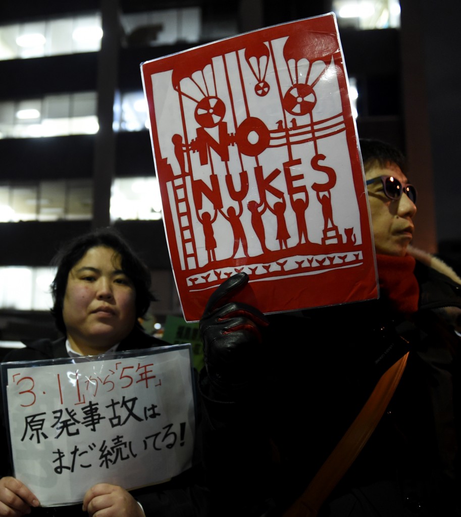 Protesters hold placards during an anti-nuclear demonstration rally in front of the Diet building in Tokyo on March 11, 2016. Hundreds of demonstratior staged the anti-nuclear rally on the fifth anniversary day of 2011 quake and tsunami disaster in northern Japan. / AFP / TOSHIFUMI KITAMURA