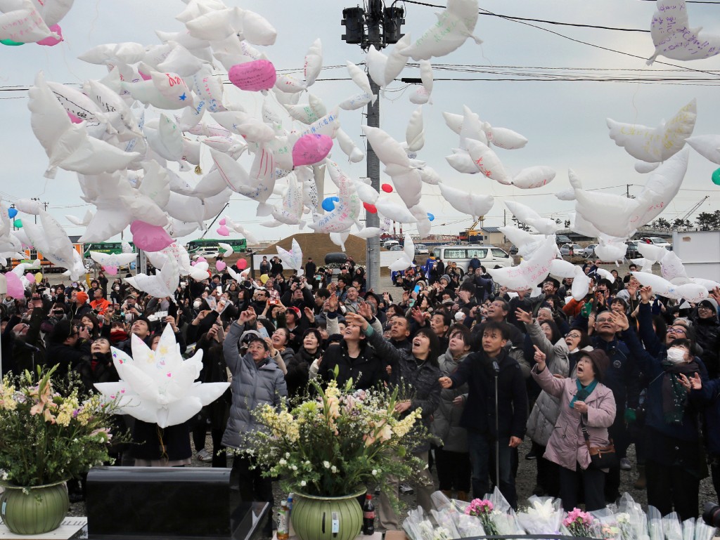 Residents release dove-shape balloons with massages for quake and tsunami victims in Natori, Miyagi prefecture on March 11, 2016. Japan pauses on March 11 to mark five years since an offshore earthquake spawned a monster tsunami that left about 18,500 people dead or missing along its northeastern coast and sparked the worst nuclear disaster in a quarter century. / AFP / JIJI PRESS / JIJI PRESS / Japan OUT