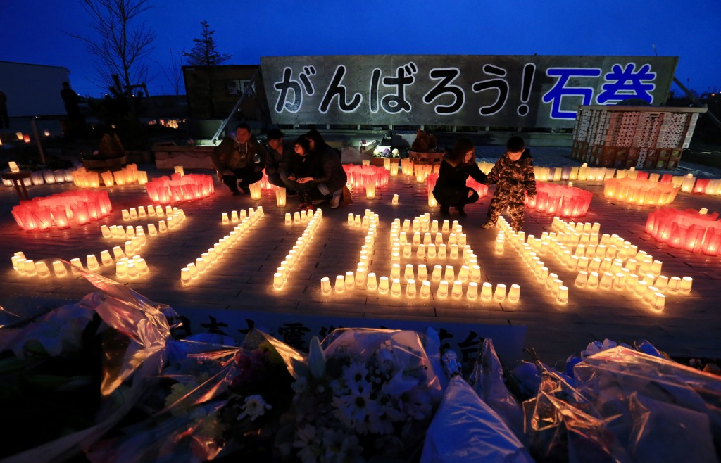 Residents lit candles saying "3.11 memorial" in Ishinomaki, Miyagi prefecture on March 11, 2016. Japan pauses on March 11 to mark five years since an offshore earthquake spawned a monster tsunami that left about 18,500 people dead or missing along its northeastern coast and sparked the worst nuclear disaster in a quarter century. / AFP / JIJI PRESS / JIJI PRESS / Japan OUT