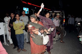 Pakistani relatives bring an injured child to the hospital in Lahore on March 27, 2016, after at least 56 people were killed and more than 200 injured when an apparent suicide bomb ripped through the parking lot of a crowded park in the Pakistani city of Lahore where Christians were celebrating Easter. / AFP / ARIF ALI