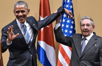 Cuban President Raul Castro (R) raises US President Barack Obama's hand during a meeting at the Revolution Palace in Havana on March 21, 2016. Cuba's Communist President Raul Castro on Monday stood next to Barack Obama and hailed his opposition to a long-standing economic "blockade," but said it would need to end before ties are fully normalized.   AFP PHOTO/Nicholas KAMM / AFP / NICHOLAS KAMM