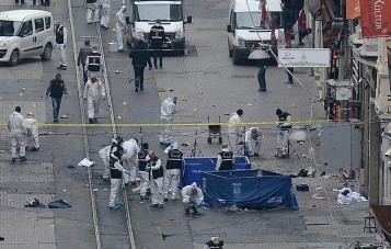 Turkish police, forensics and emergency services work on the scene of an explosion on the pedestrian Istiklal avenue in Istanbul on March 19, 2016. Four people, including the bomber, were killed and twenty others injured in a suicide attack on a major shopping street in Istanbul on Saturday, the city governor reported. / AFP / ILHAS NEWS AGENCY / STR