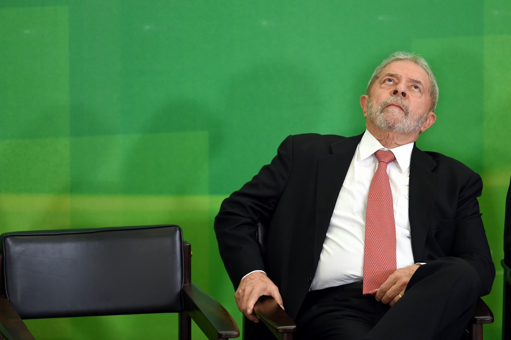 Former Brazilian president Luiz Inacio Lula da Silva gestures next to Brazilian president Dilma Rousseff (out of frame) after Lula's sworn in as chief of staff, in Brasilia on March 17, 2016. Rousseff appointed Lula da Silva as her chief of staff hoping that his political prowess can save her administration. The president is battling an impeachment attempt, a deep recession, and the fallout of an explosive corruption scandal at state oil giant Petrobras. AFP PHOTO/EVARISTO SA EVARISTO SA / AFP / AFP / EVARISTO SA