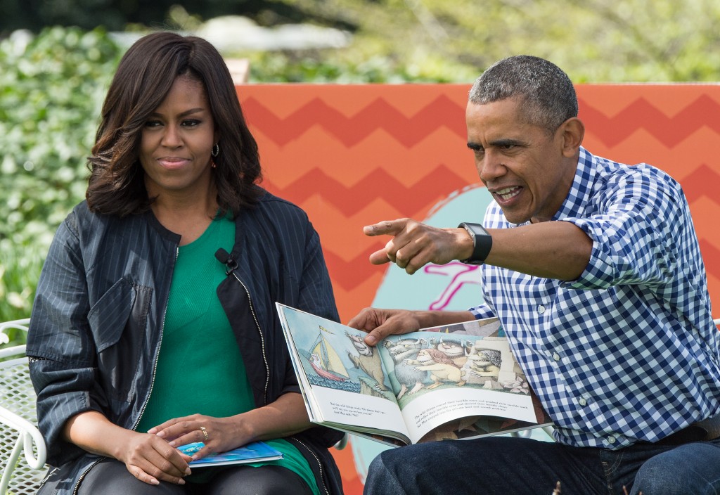 US President Barack Obama and First Lady Michelle Obama read Maurice Sendak's "Where the Wild Things Are" to children at the annual Easter Egg Roll at the White House in Washington, DC, on March 28, 2016. Some 35,000 guests have been invited to participate in the 138th annual Easter Egg roll. The theme of the day's event is Let's Celebrate!  / AFP / Nicholas Kamm