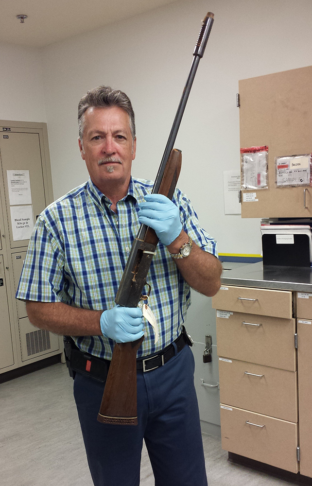 In this June 2015 photo released by the Seattle Police on Thursday, March 17, 2016, Detective Michael Ciesynski holds the shotgun which rock legend Kurt Cobain used to kill himself on April 8, 1994. Police did not say why they took the photos last year or why they're releasing them to the public at this time. (Seattle Police via AP)