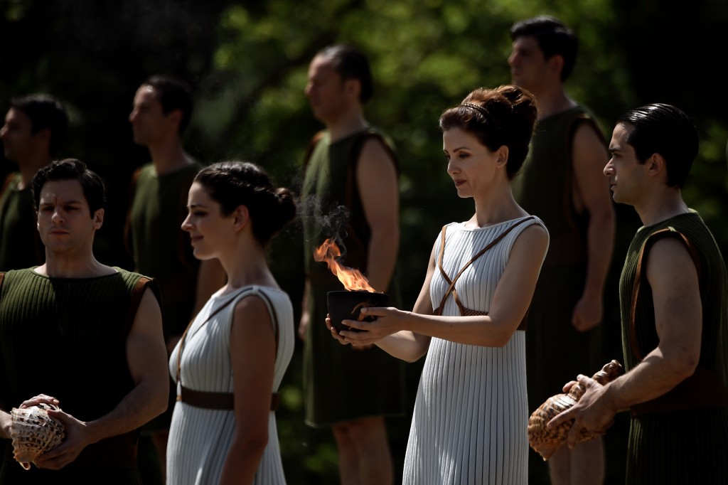 Greek actress Katerina Lechou, acting as the high priestess, holds a cauldron with the Olympic flame at the ancient stadium of Olympia on April 20, 2016, during a dress rehearsal of the lighting ceremony of the Olympic flame in ancient Olympia, the sanctuary where the Olympic Games were born in 776 BC. / AFP PHOTO / ARIS MESSINIS