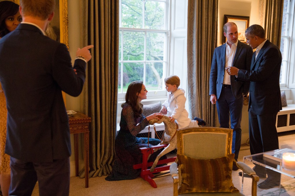 A handout picture released by Kensington Palace on April 22, 2016 shows Britain's Prince George of Cambridge (R) playing on a rocking horse with his mother Catherine, Duchess of Cambridge, as US President Barack Obama (R) and Prince William, Duke of Cambridge (2R) and US First Lady Michelle Obama (L) and Prince Harry (2L) talk at Kensington Palace in London on April 22, 2016. / AFP PHOTO / KENSINGTON PALACE / WHITE HOUSE PHOTOGRAPHER / PETE SOUZA / RESTRICTED TO EDITORIAL USE, NO COMMERCIAL USE, NO ADVERTISING, NO MERCHANDISING, MANDATORY CREDIT "AFP / KENSINGTON PALACE / WHITEHOUSE PHOTOGRAPHER / PETE SOUZA" RESTRICTED TO SUBSCRIPTION USE - NO SALES - DISTRIBUTED AS A SERVICE TO CLIENTS