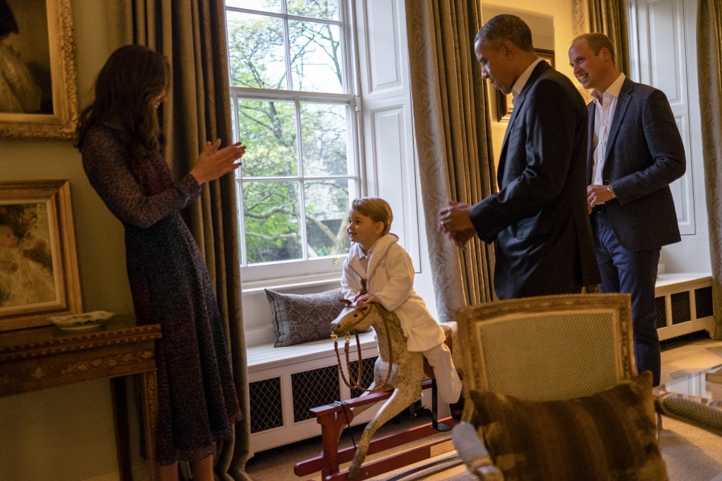 A handout picture released by Kensington Palace on April 22, 2016 shows Britain's Prince George of Cambridge (2L) playing on a rocking horse while his mother Catherine, Duchess of Cambridge (L), US President Barack Obama (2R) and Prince William, Duke of Cambridge (R) watch at Kensington Palace in London on April 22, 2016. / AFP PHOTO / KENSINGTON PALACE / WHITE HOUSE PHOTOGRAPHER / PETE SOUZA / RESTRICTED TO EDITORIAL USE, NO COMMERCIAL USE, NO ADVERTISING, NO MERCHANDISING, MANDATORY CREDIT "AFP / KENSINGTON PALACE / WHITEHOUSE PHOTOGRAPHER / PETE SOUZA" RESTRICTED TO SUBSCRIPTION USE - NO SALES - DISTRIBUTED AS A SERVICE TO CLIENTS