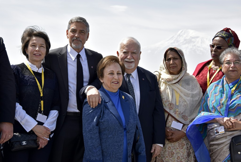 Aurora Prize co-founders, Selection Committee members, finalists, including Hollywood star and rights advocate George Clooney (2nd L) and guests pose in front of Mount Ararat while visiting the Genocide Memorial in Yerevan on April 24, 2016, to commemorate the 101st anniversary of the World War I-era Armenian genocide in the Ottoman Empire. A staunch advocate of the massacre's recognition as genocide, Clooney arrived in the ex-Soviet nation on April 23 to take part in the hugely symbolic ceremonies. / AFP PHOTO / KAREN MINASYAN