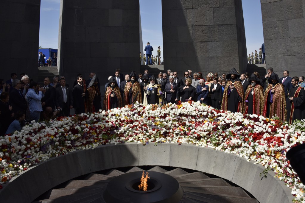 Armenian President Serzh Sarkisian (C,R) and US actor George Clooney (C) attend a ceremony at the Genocide Memorial in Yerevan on April 24, 2016, to commemorate the 101st anniversary of the World War I-era Armenian genocide in the Ottoman Empire. A staunch advocate of the massacre's recognition as genocide, Clooney arrived in the ex-Soviet nation on April 23 to take part in the hugely symbolic ceremonies. / AFP PHOTO / KAREN MINASYAN