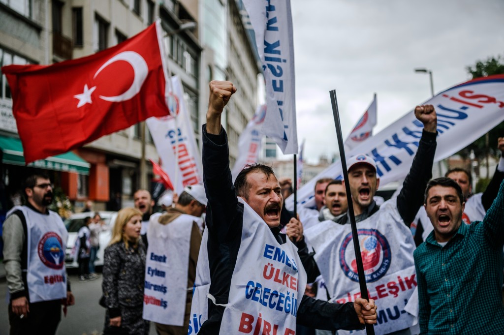 Demonstrators shout slogans and hold up their fists during a May Day rally in Sisli, a district of Istanbul, on May 1, 2016.  Turkish labour activists and leftists marked the annual May Day holiday, with thousands of security deployed and bracing for trouble after the authorities refused to allow protests in central Taksim Square. / AFP PHOTO / OZAN KOSE