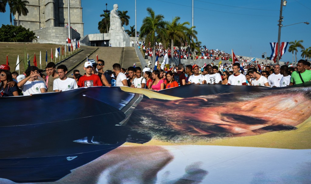 People display an image of Cuban former president Fidel Castro during the May Day parade at Revolution Square in Havana, on May 1, 2016. / AFP PHOTO / JORGE BELTRAN