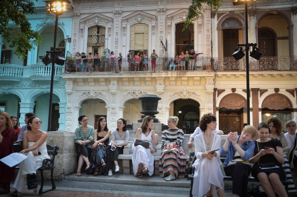 From their houses (at back) Cubans try to watch the Chanel performance at the Prado promenade in Havana, on May 3, 2016. / AFP PHOTO / ADALBERTO ROQUE