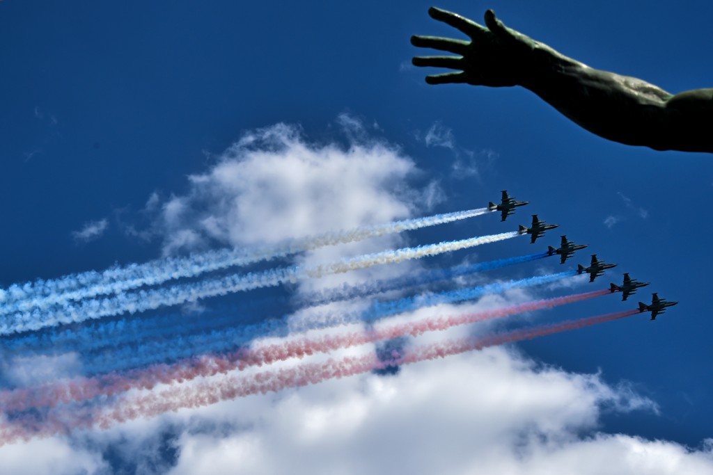 Russian Su-25 assault aircrafts release smoke in the colours of the Russian flag while flying over Red Square during the Victory Day military parade general rehearsal in Moscow on May 7, 2016 / AFP PHOTO / KIRILL KUDRYAVTSEV
