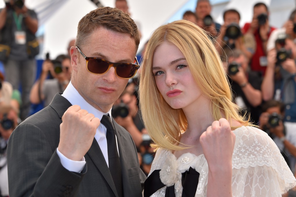 Danish director Nicolas Winding Refn (L) and US actress Elle Fanning pose on May 20, 2016 during a photocall for the film "The Neon Demon" at the 69th Cannes Film Festival in Cannes, southern France. / AFP PHOTO / LOIC VENANCE