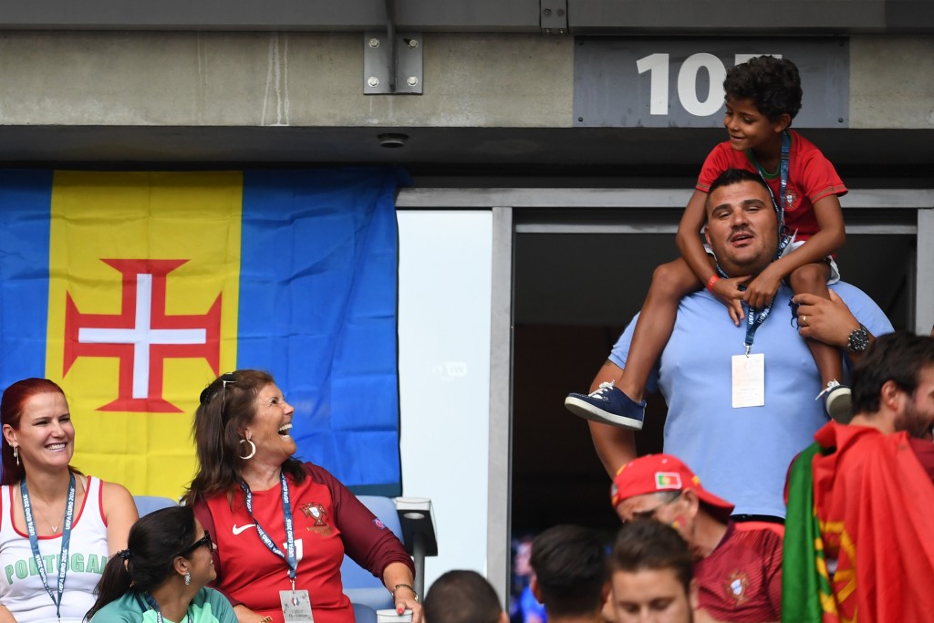 Portugal's forward Cristiano Ronaldo's mother Maria Dolores dos Santos Aveiro (C) looks at her grandchild Cristiano Junior (top) next to her daughter Elma Aveiro (L) as they cheer ahead of the Euro 2016 final football match between Portugal and France at the Stade de France in Saint-Denis, north of Paris, on July 10, 2016. / AFP PHOTO / FRANCISCO LEONG