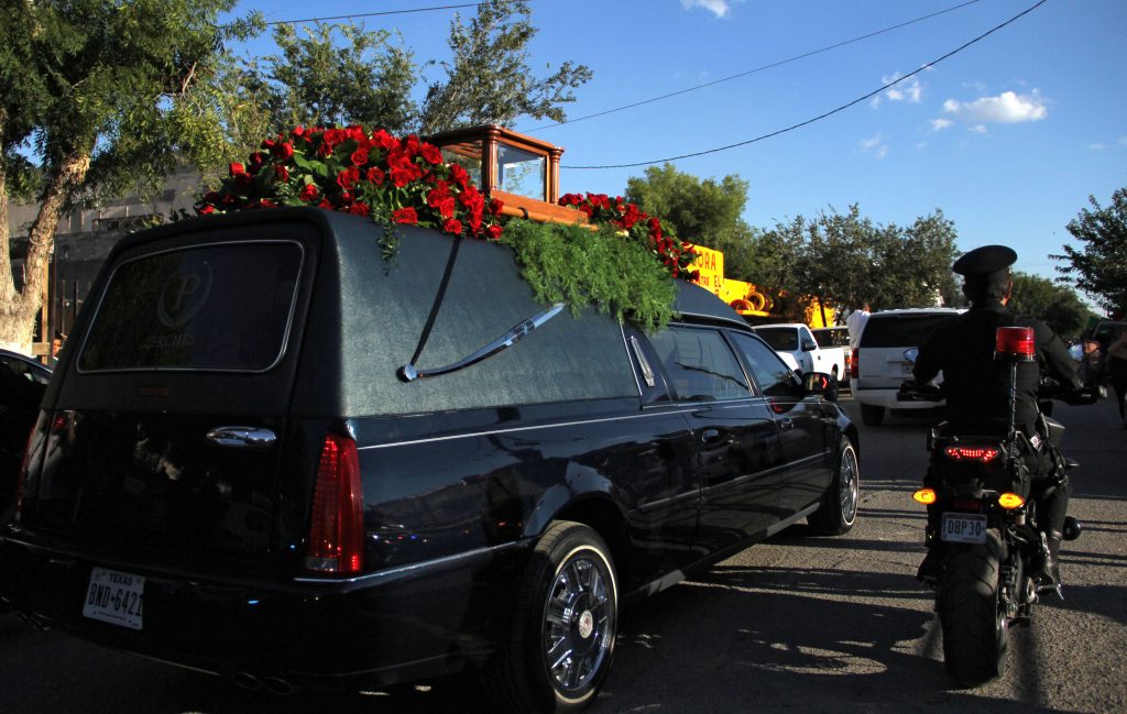 Police escort the hearse carrying the urn (on top) containing the ashes of Mexican singer-songwriter Juan Gabriel as it arrives at Ciudad Juarez in Chihuahua state, Mexico on September 3, 2016. The ashes of Juan Gabriel arrived Saturday to Ciudad Juarez from the United States, where he lived, and where he died on August 28, at age 66. / AFP PHOTO / HERIKA MARTINEZ