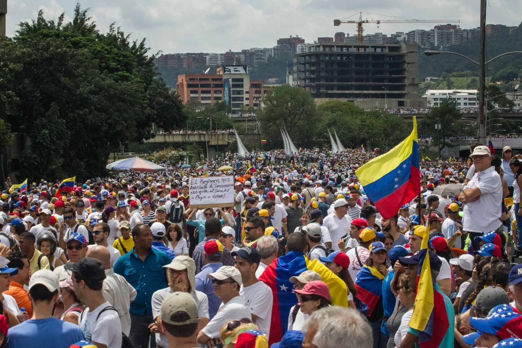 CAR07. CARACAS (VENEZUELA) 26/10/2016.- Un grupo de personas participa hoy, miércoles 26 de octubre de 2016, en una manifestación denominada "Toma de Venezuela" en Caracas (Venezuela), organizada por la alianza opositora y que reunió a decenas de miles de personas. La Mesa de la Unidad Democrática (MUD) convocó a una huelga general de 12 horas el próximo 28 de octubre en todo el país, así como a una manifestación hacia el palacio presidencial el 3 de noviembre. EFE/MIGUEL GUTIÉRREZ