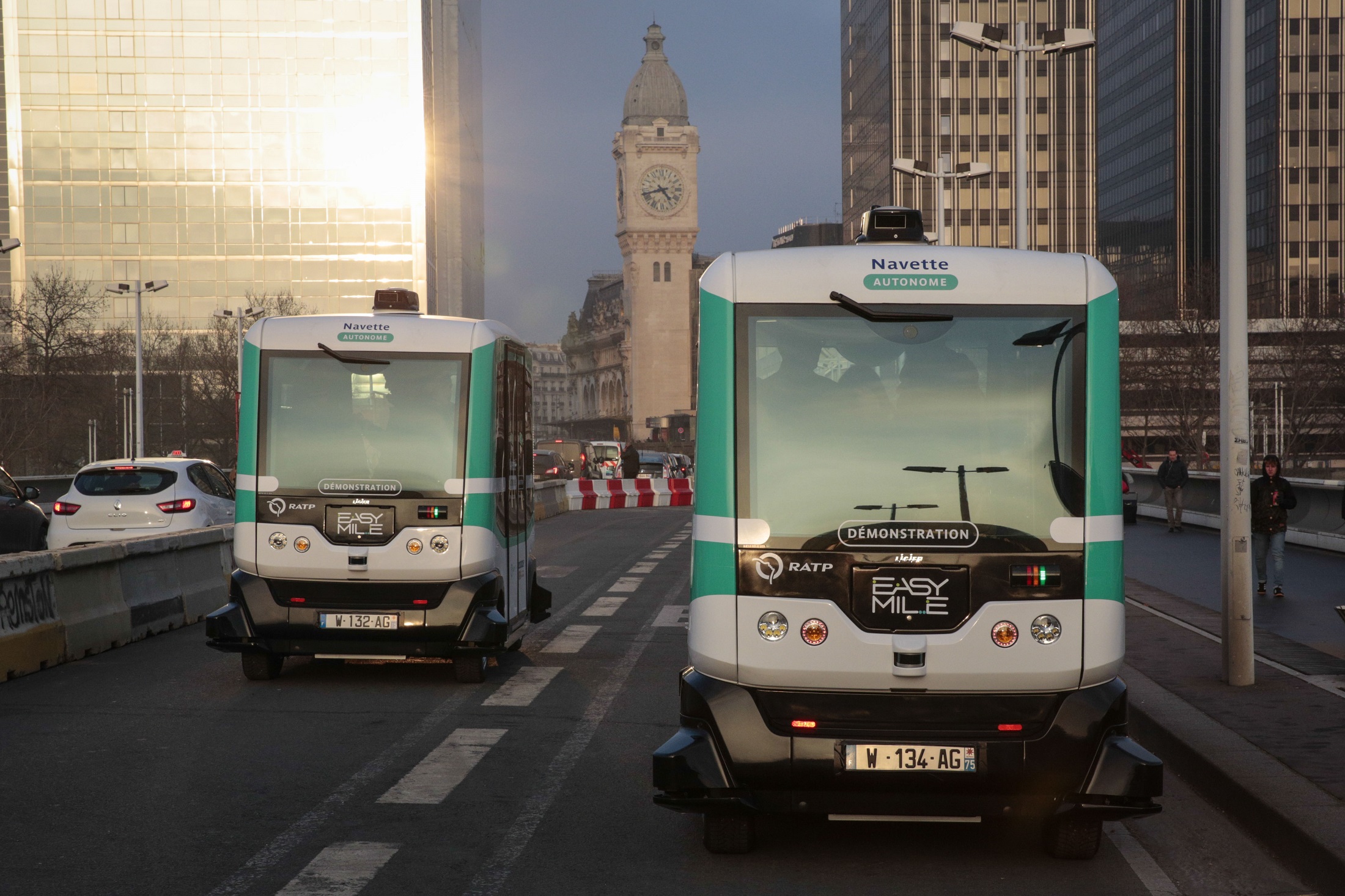 Two self-driving bus shuttles between Austrelitz station and Lyon station in Paris, produced by Easymile company in Paris on January 23, 2017. The RATP tests two autonomous and electric minibuses in Paris, they will transport passengers between the stations of Lyon and Austerlitz for a little over two months free of charge on a dedicated lane. / AFP PHOTO / GEOFFROY VAN DER HASSELT