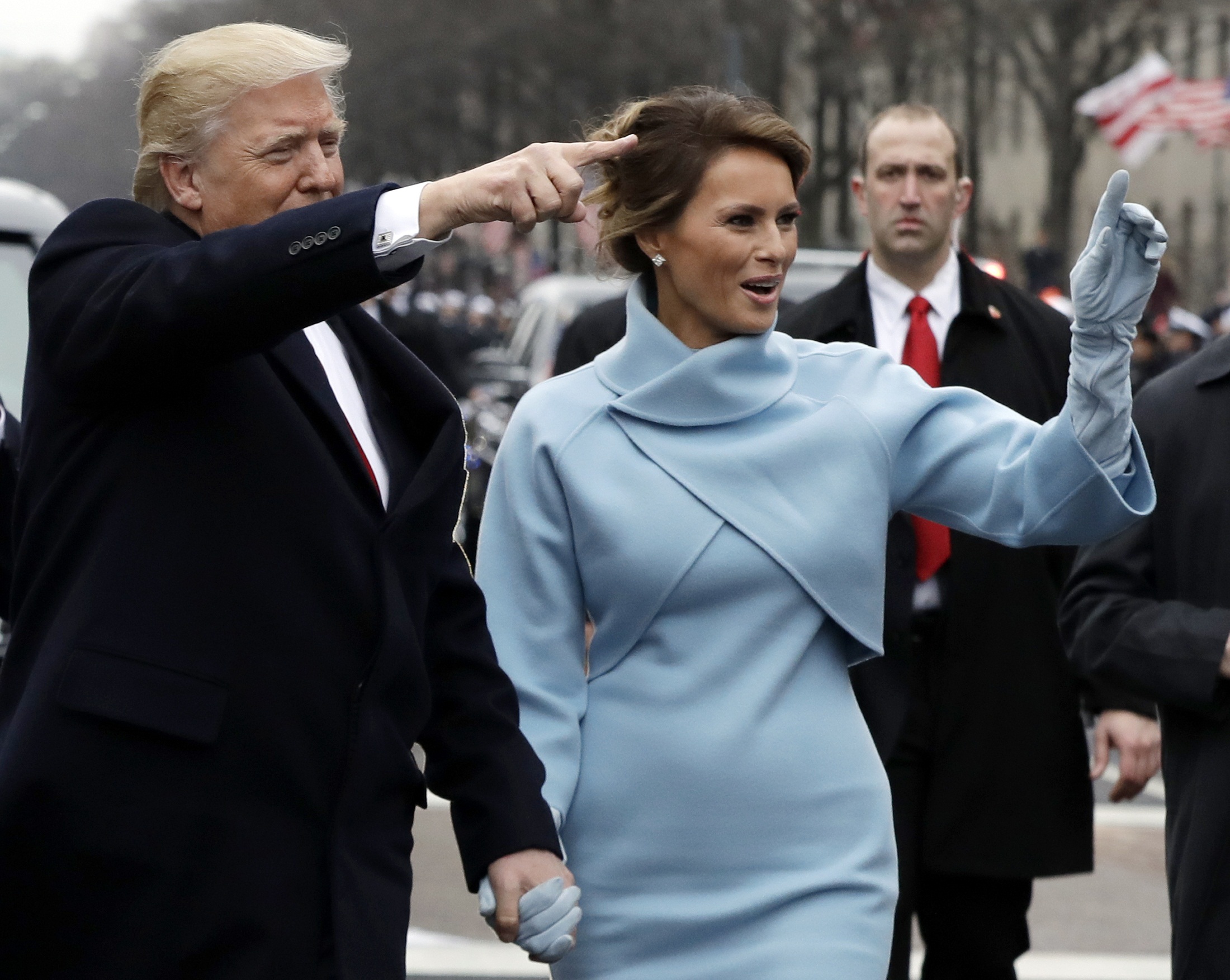 President Donald Trump waves as he walks with first lady melania Trump during the inauguration parade on Pennsylvania Avenue in Washington, DC, on January 20, 2107 following swearing-in ceremonies on Capitol Hill earlier today.  / AFP PHOTO / POOL / Evan Vucci