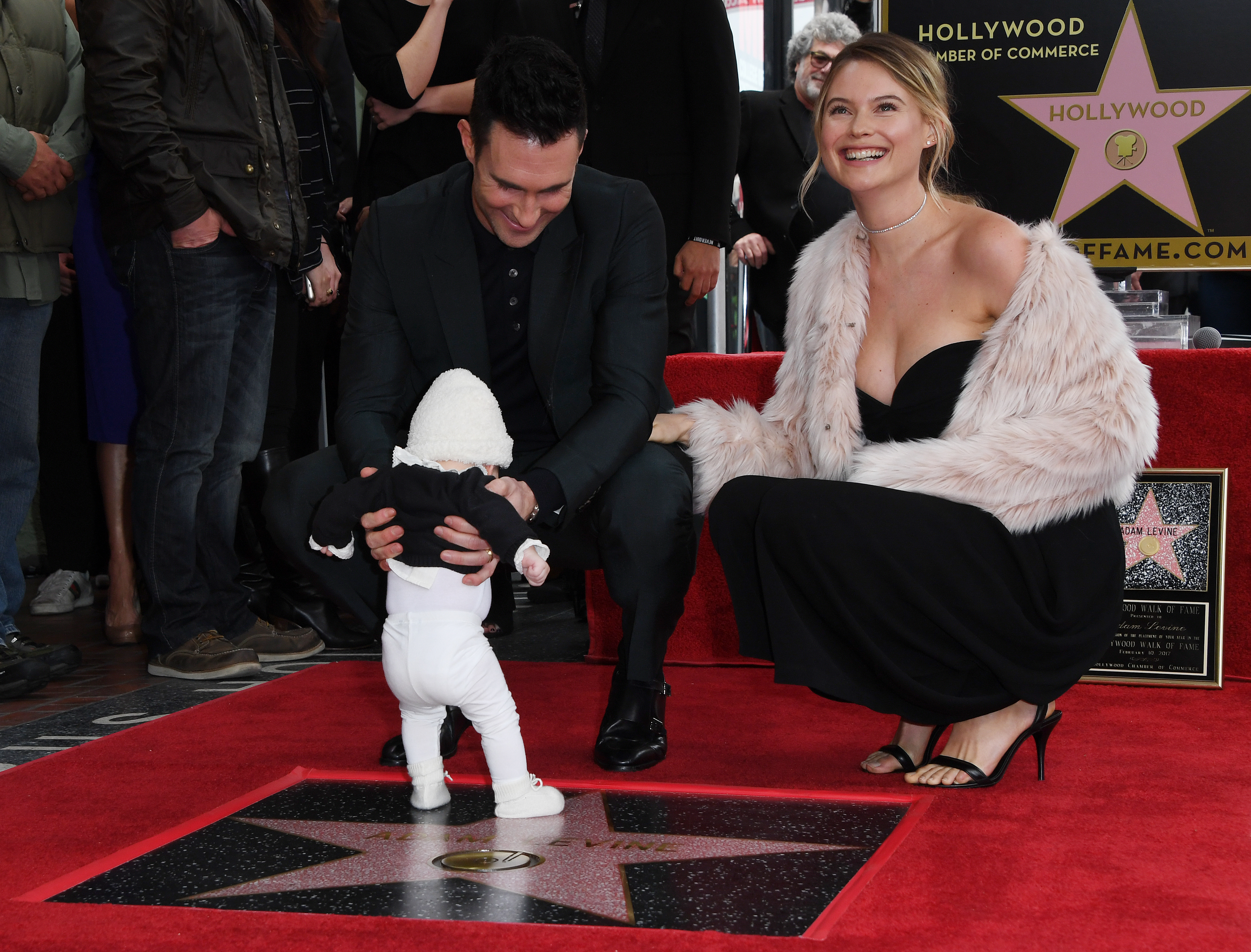 Recording artist Adam Levine (L) with wife model Behati Prinsloo and daughter Dusty Rose pose after he was honored with a Star on the Hollywood Walk of Fame in Hollywood, California, on February 10, 2017. / AFP PHOTO / Mark RALSTON