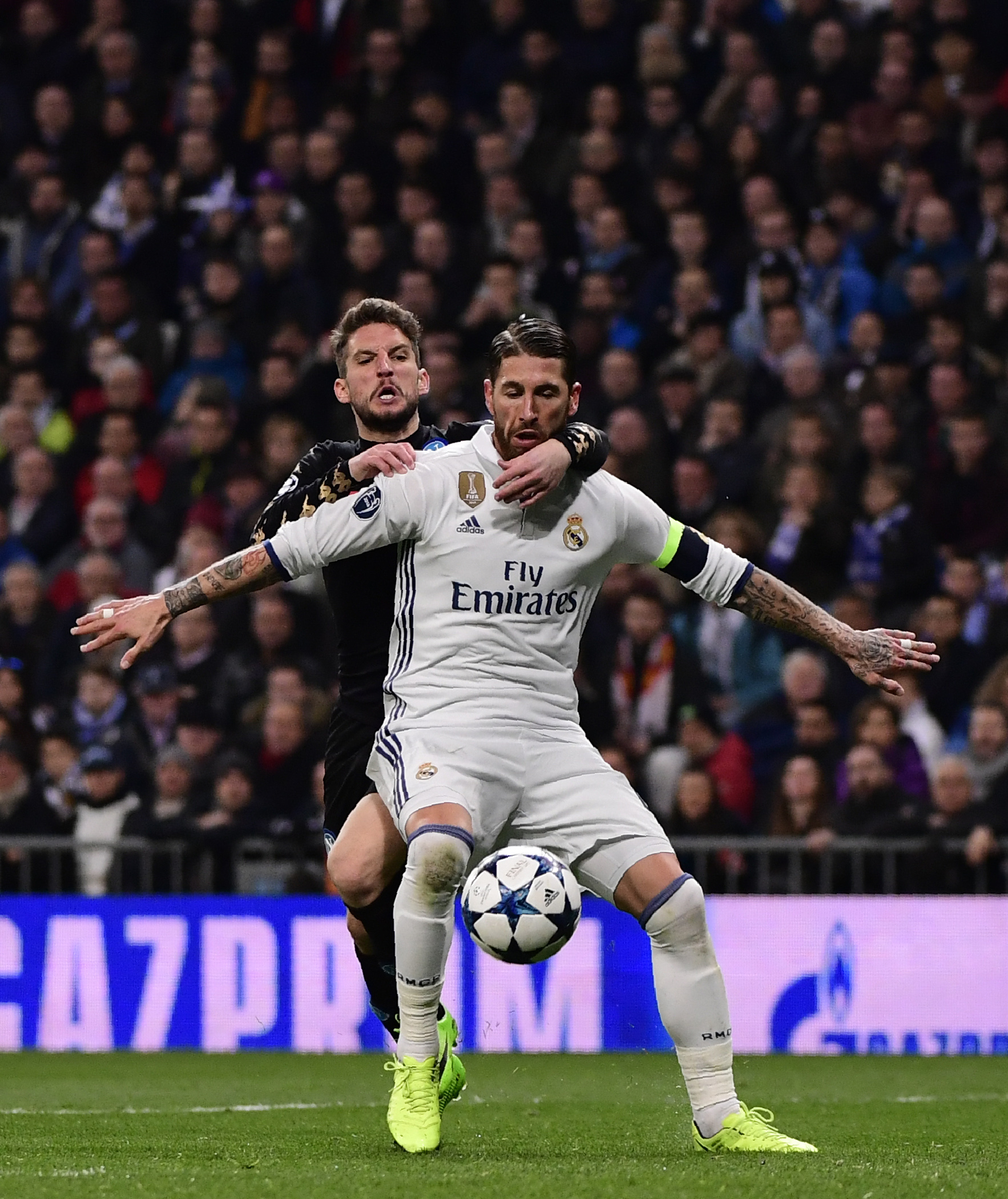 Napoli's forward from Belgium Dries Mertens (L) vies wth Real Madrid's defender Sergio Ramos during the UEFA Champions League round of 16 first leg football match Real Madrid CF vs SSC Napoli at the Santiago Bernabeu stadium in Madrid on February 15, 2017. / AFP PHOTO / PIERRE-PHILIPPE MARCOU