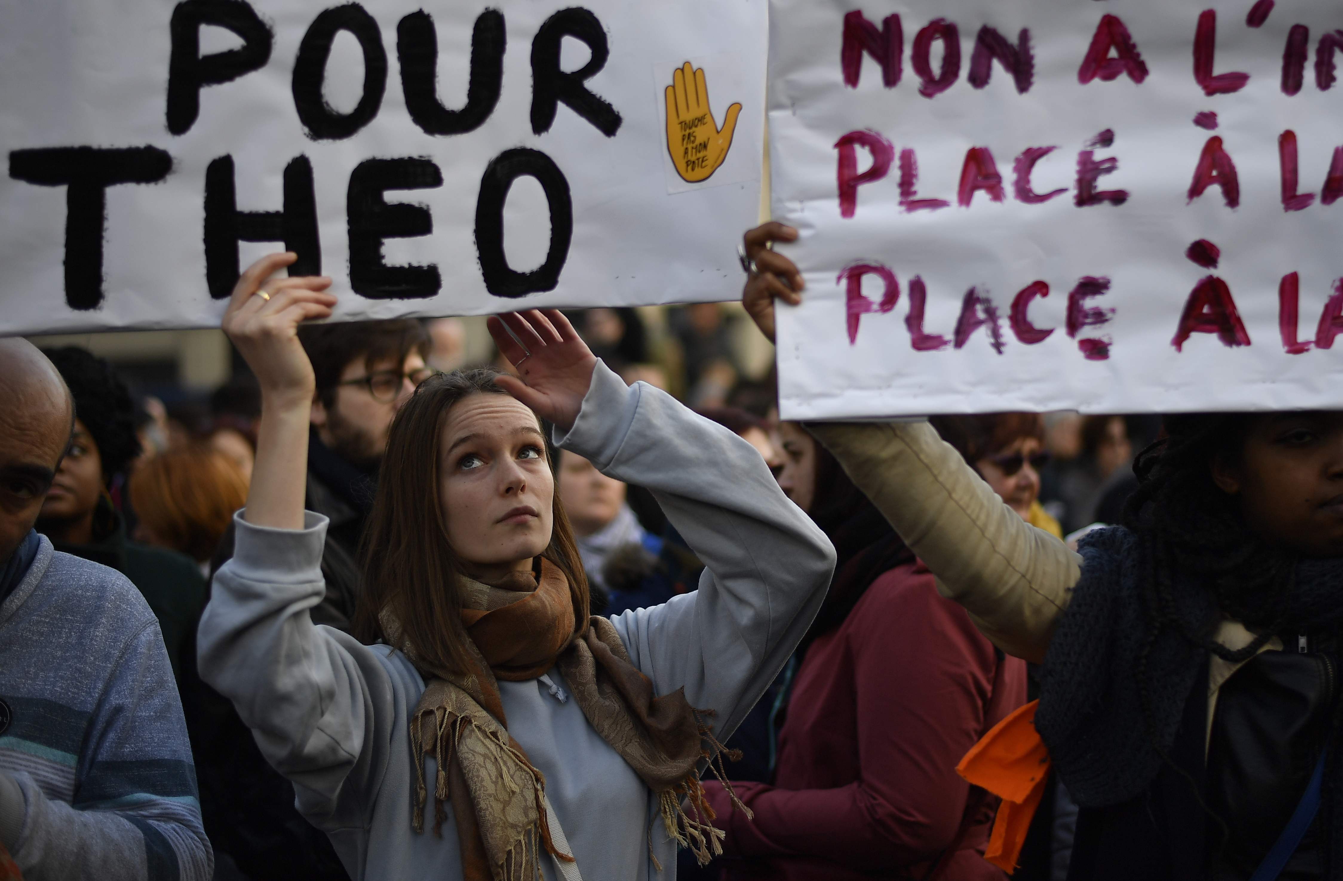 Protesters hold banners during a demonstration against police brutality on February 18, 2017 on the place de la Republique in Paris, following the alleged rape of a black youth, identified only as Theo, with a police baton, an incident that has sparked 10 nights of rioting and more than 200 arrests. The injuries sustained by Theo during a stop-and-search operation on February 2 in the suburb of Aulnay-sous-Bois, has revived long-simmering frustrations over policing in immigrant communities, where young men accuse the police of repeatedly targeting them in aggressive stop-and-search operations and using excessive force during arrests.  / AFP PHOTO / Lionel BONAVENTURE