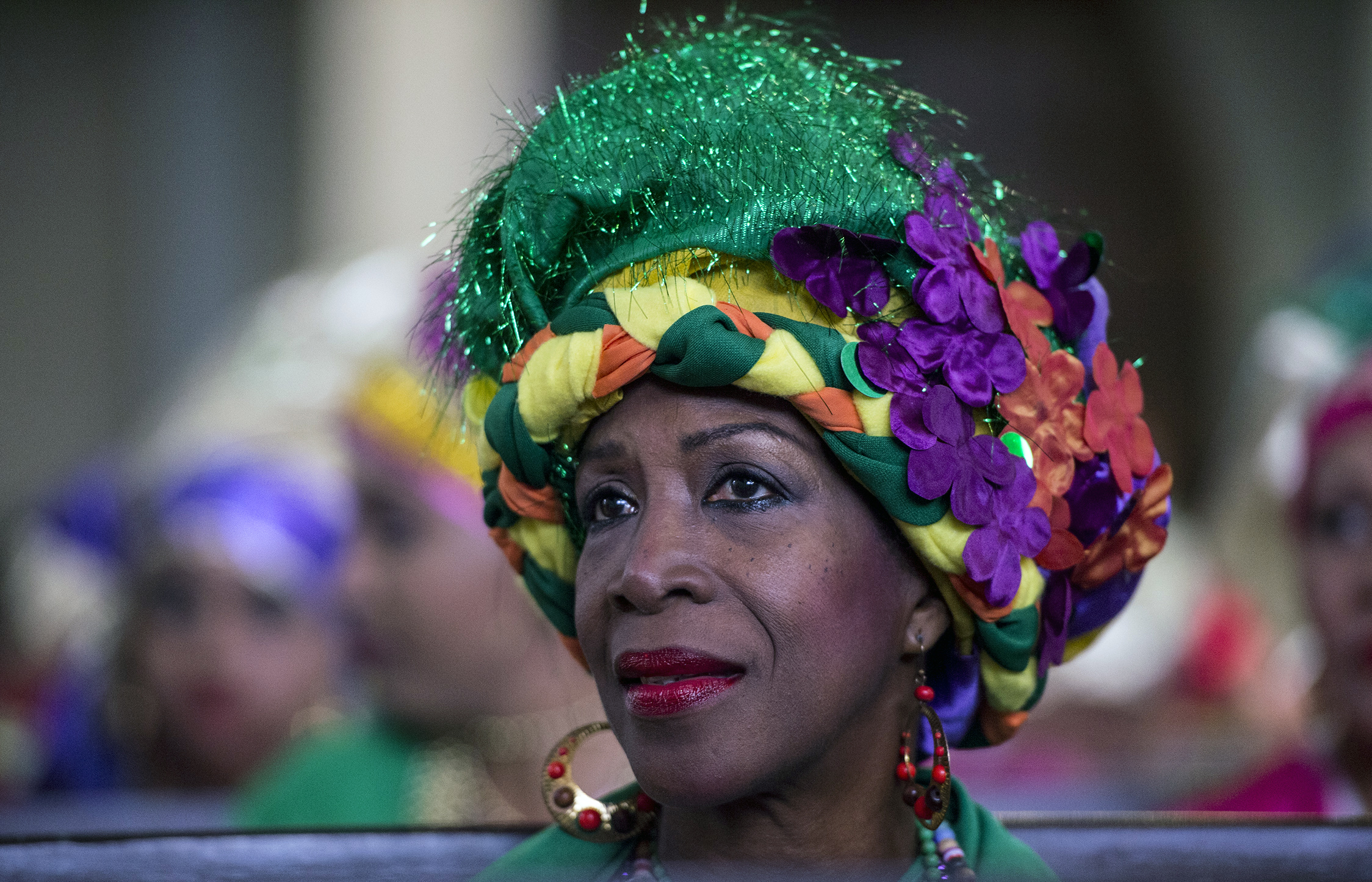 A woman dressed as "madama" attend a mass before the beginning of the Carnival in El Callao, Bolivar state, Venezuela on February 26, 2017.  El Callao's carnival was recently named Unesco's Intangible Cultural Heritage of Humanity and is led by the madamas, the pillars of Callaoense identity representing Antillean matrons considered the communicators of values, who dance and wear colourful dresses. / AFP PHOTO / JUAN BARRETO