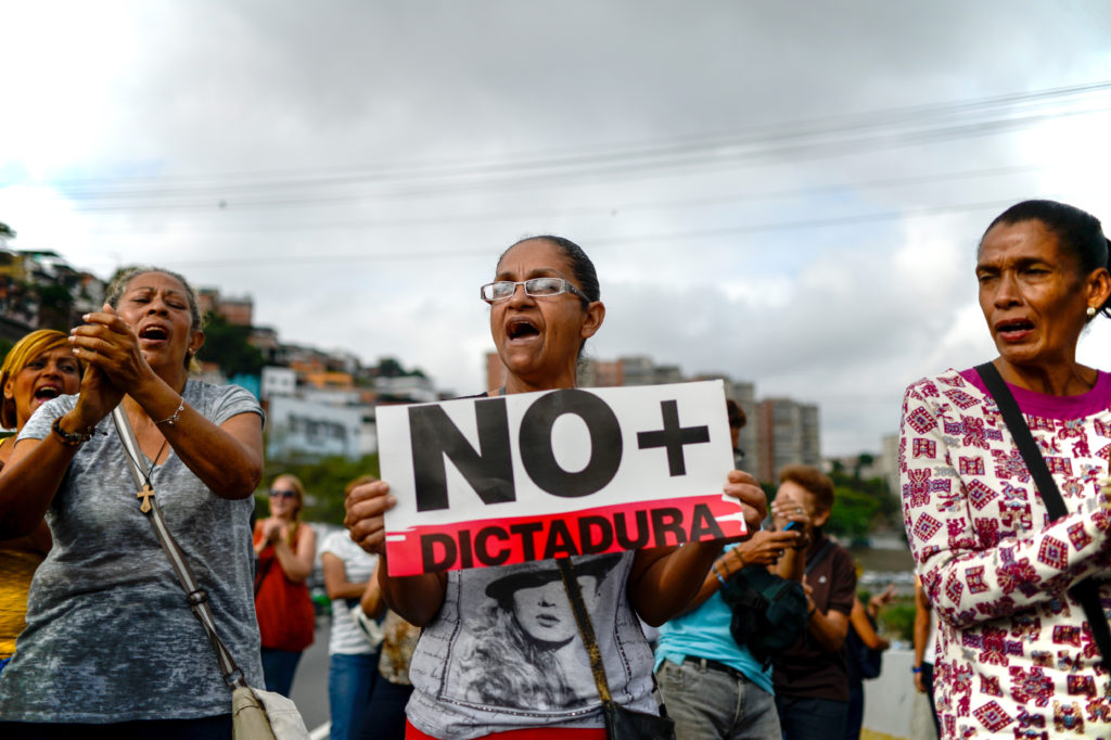 Venezuelan opposition activists march along a street of Caracas on March 31, 2017 chanting slogans against the government of President Nicolas Maduro. Venezuela's attorney general Luisa Ortega surprisingly broke ranks with President Nicolas Maduro on Friday, condemning recent Supreme Court rulings that consolidated the socialist president's power as a "rupture of constitutional order." / AFP PHOTO / FEDERICO PARRA